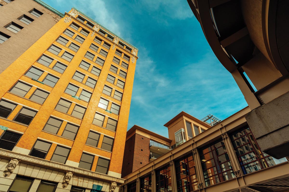 Minneapolis buildings and an overhead walkway as seen from a low angle looking up at a blue sky