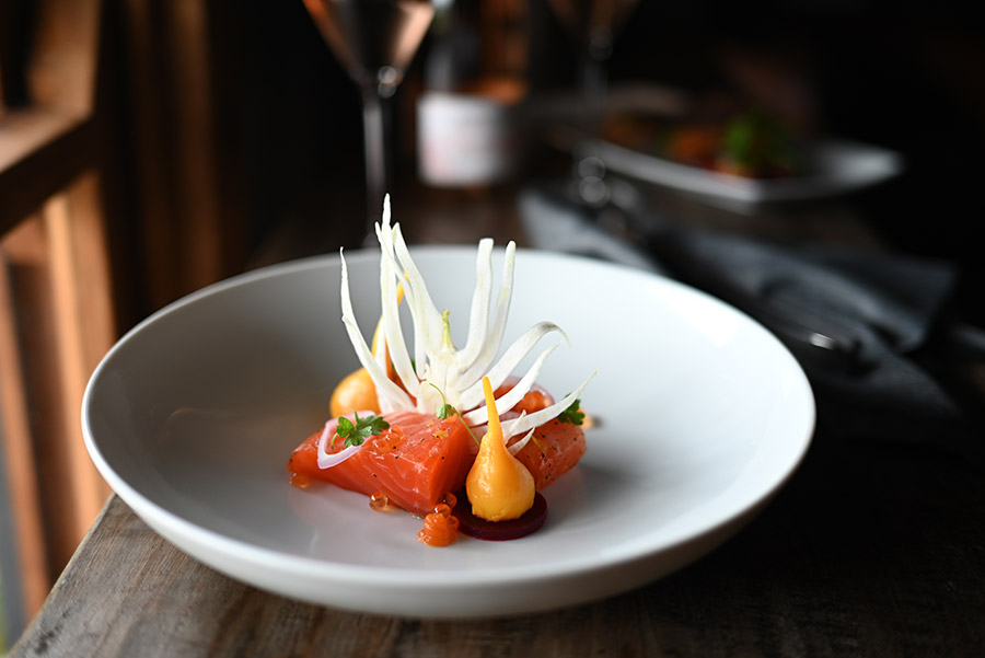 A white dish plated with sushi on a table with a soft, out of focus background