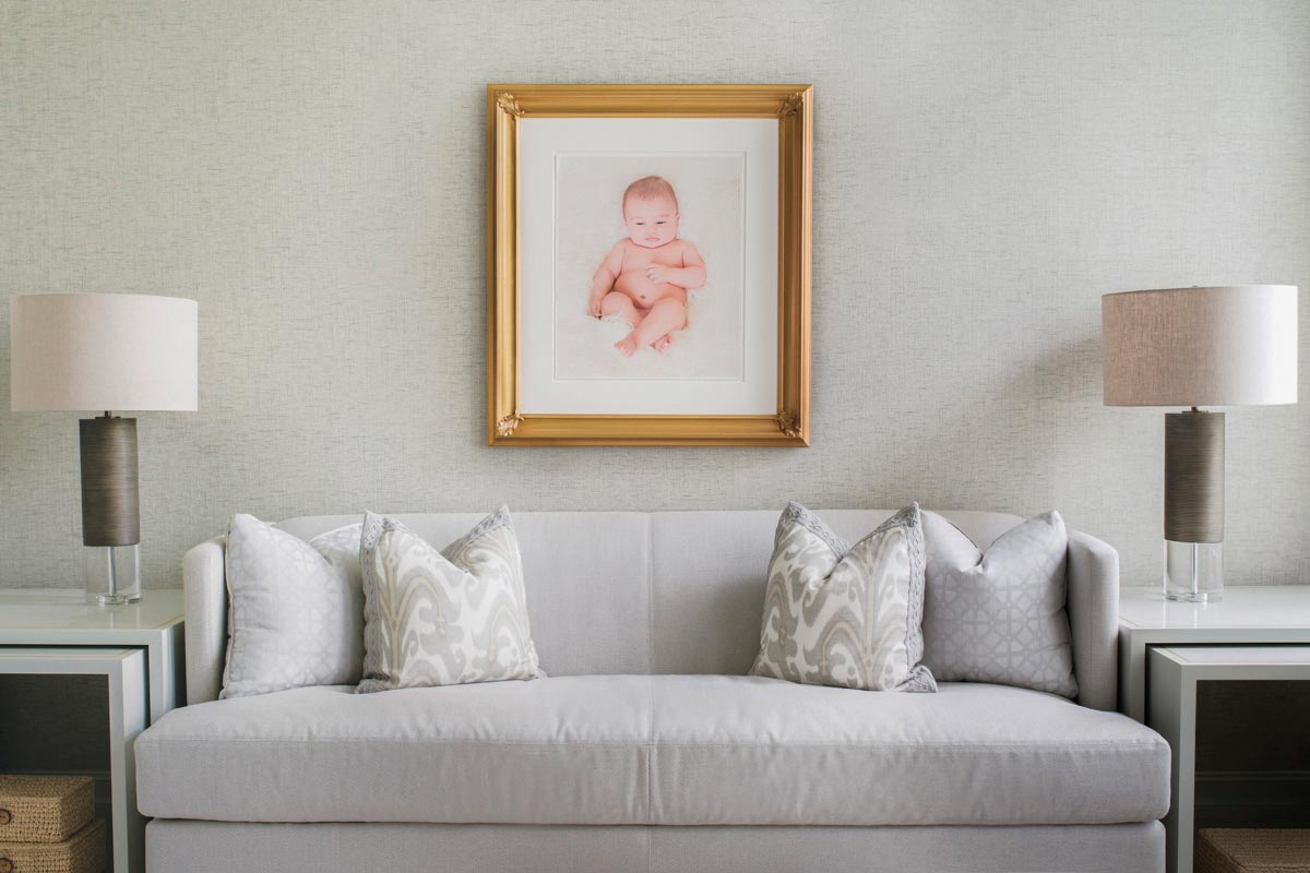white living room sofa with portrait hanging above it
