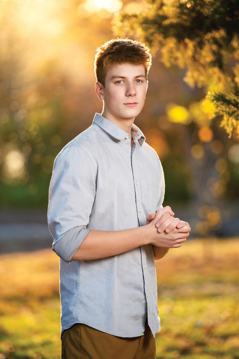 high school senior portrait by Kristina Carlson of a boy standing in nature