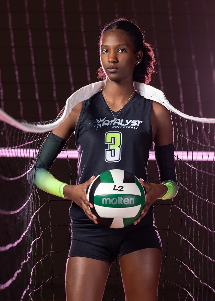 a female high school volleyball athlete with a volleyball net draped over her shoulders