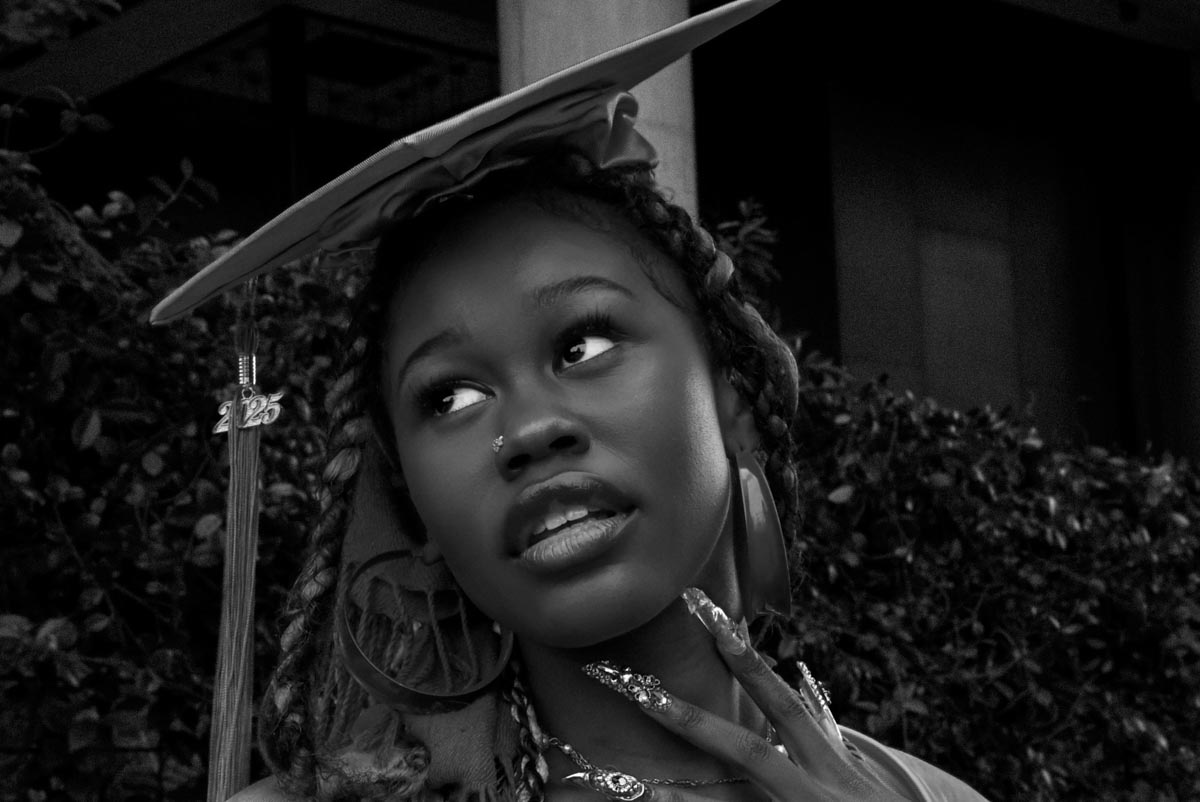 black-and-white photo of a girl wearing a graduation cap looking to her right
