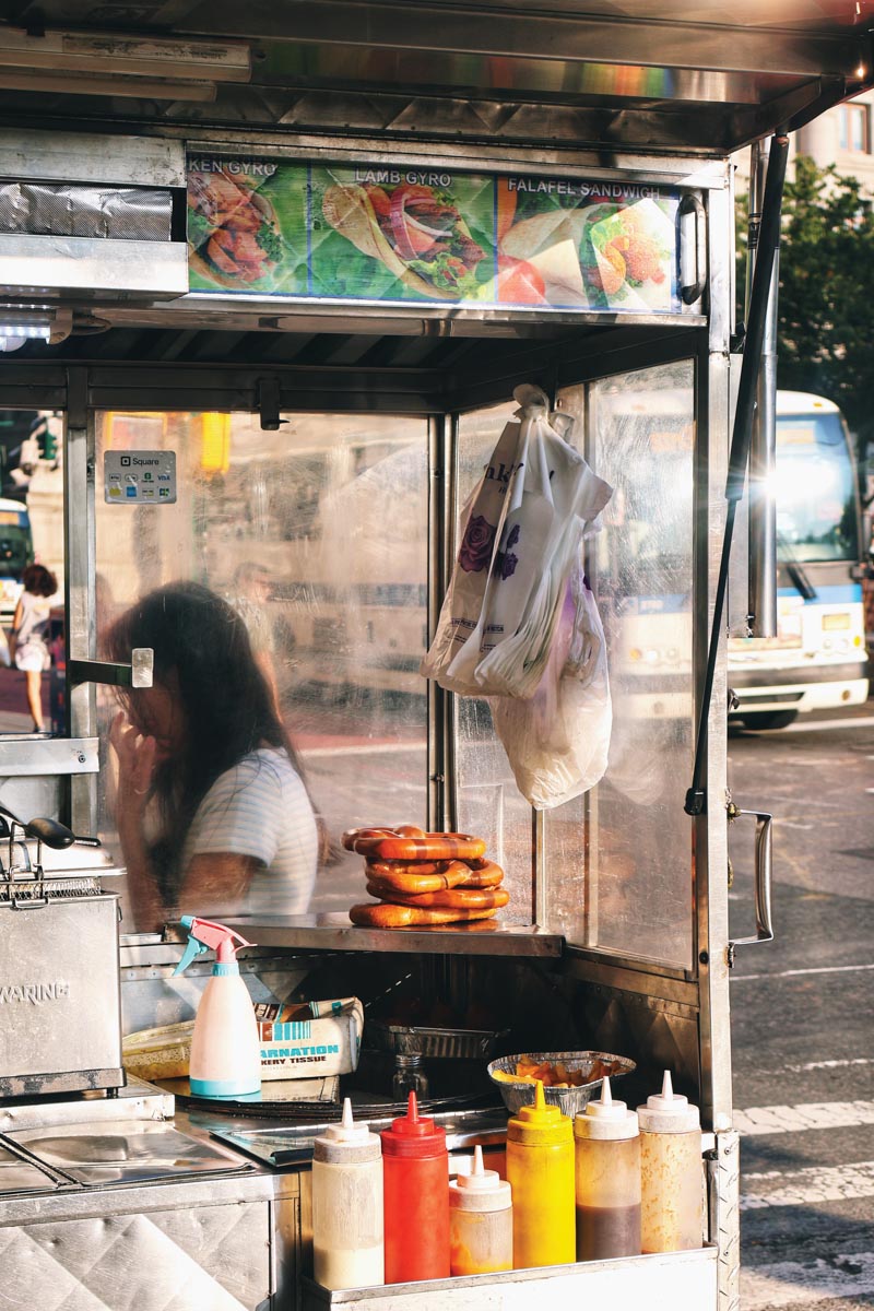 a hot dog stand on a city street