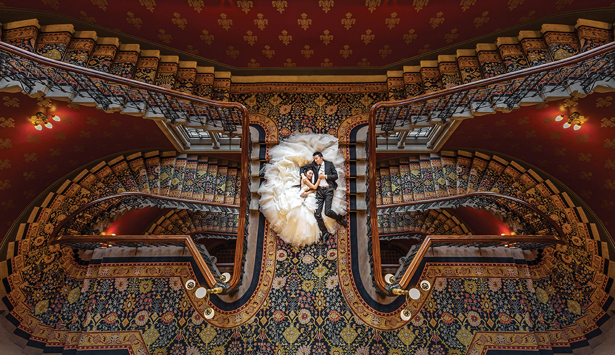 Bride and groom lying on ornate staircase