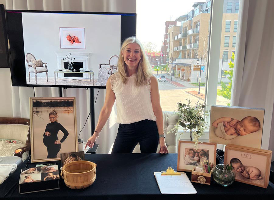 Maternity, newborn, and family portrait photographer Julie Collins staffs her table at a Love Your Belly event.