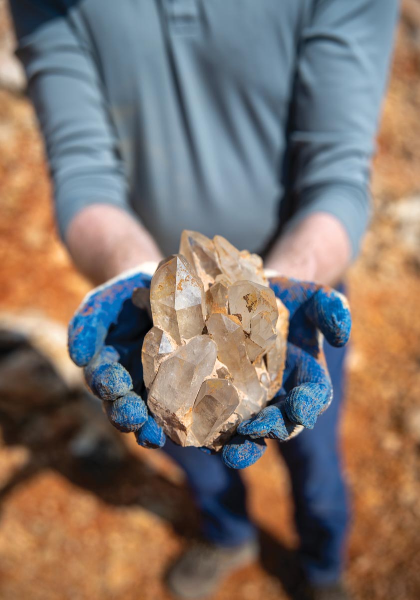 Crystal cluster held in gloved hands