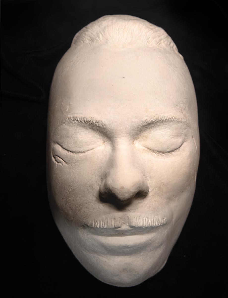 white clay death mask of John Dillinger against an all black background