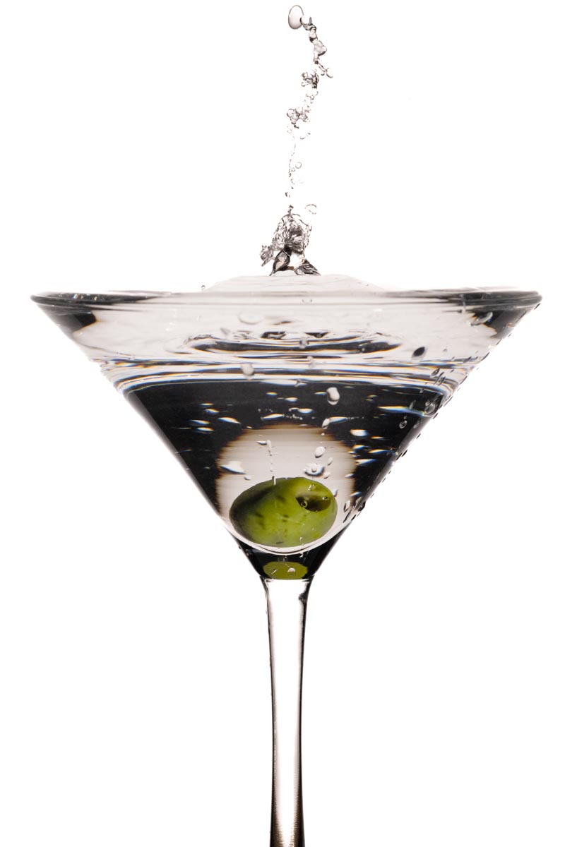 martini glass with olive and splash