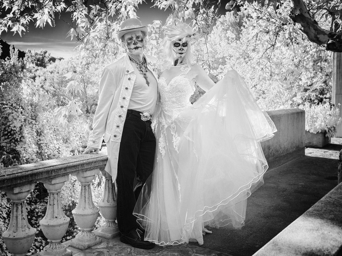 an infrared photo of a couple dressed up in Day of the Dead costumes