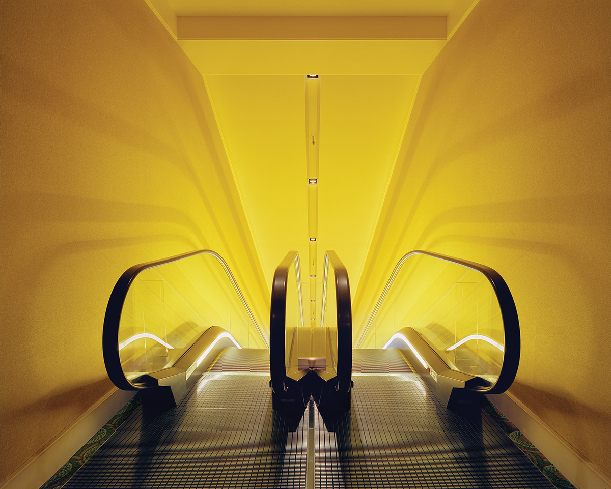 Top of escalator with yellow walls