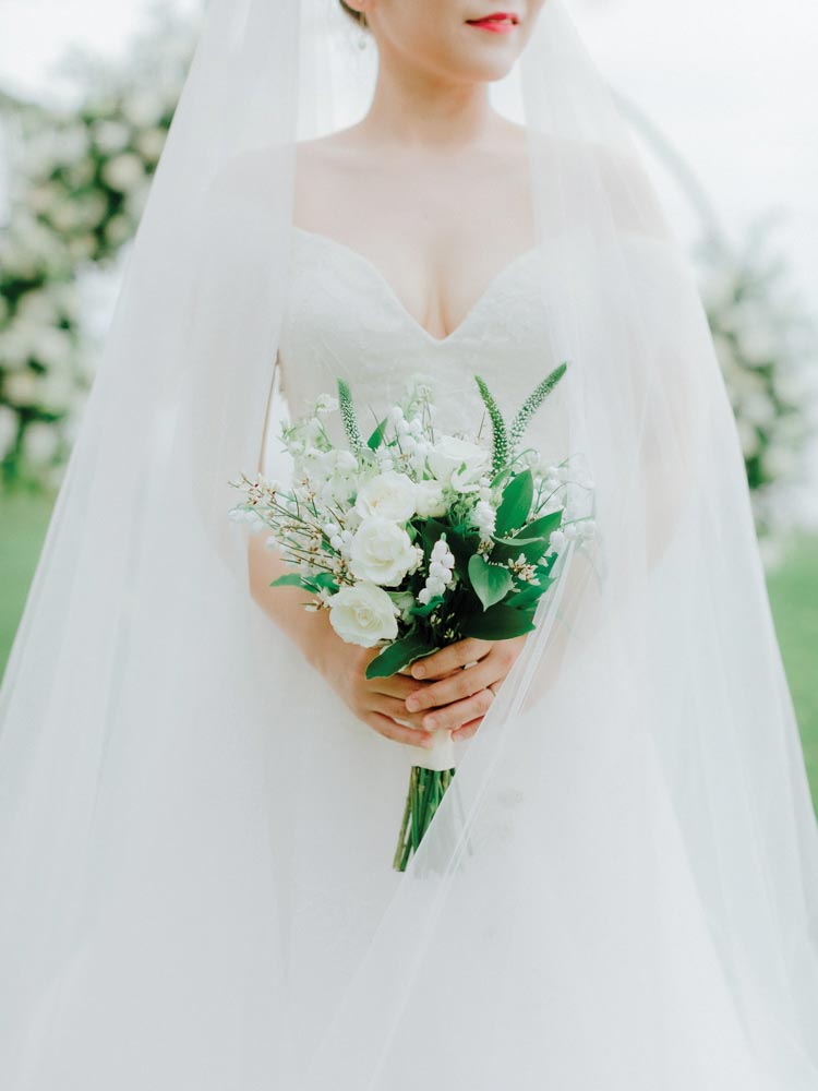 bride wearing veil holding bouquet